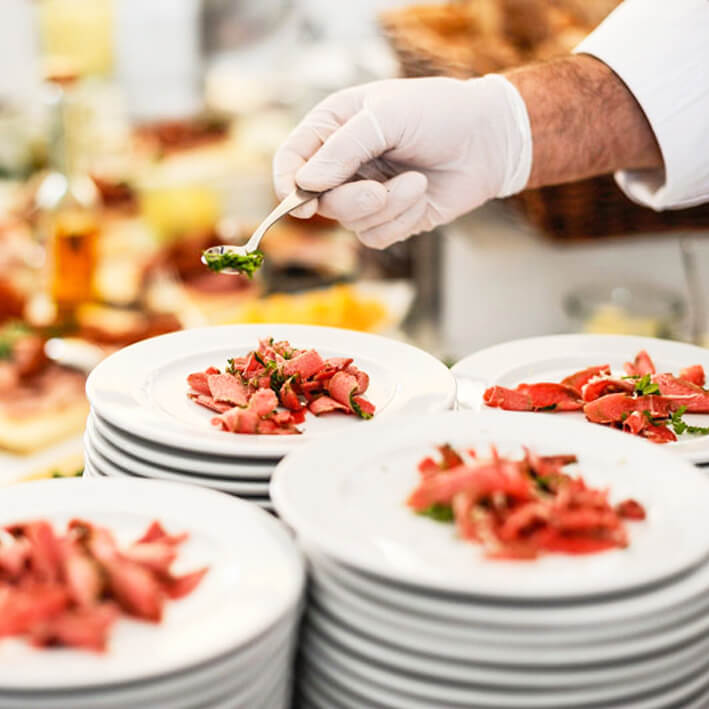 Anrichten von Speisen in der Cateringküche von Optimahl